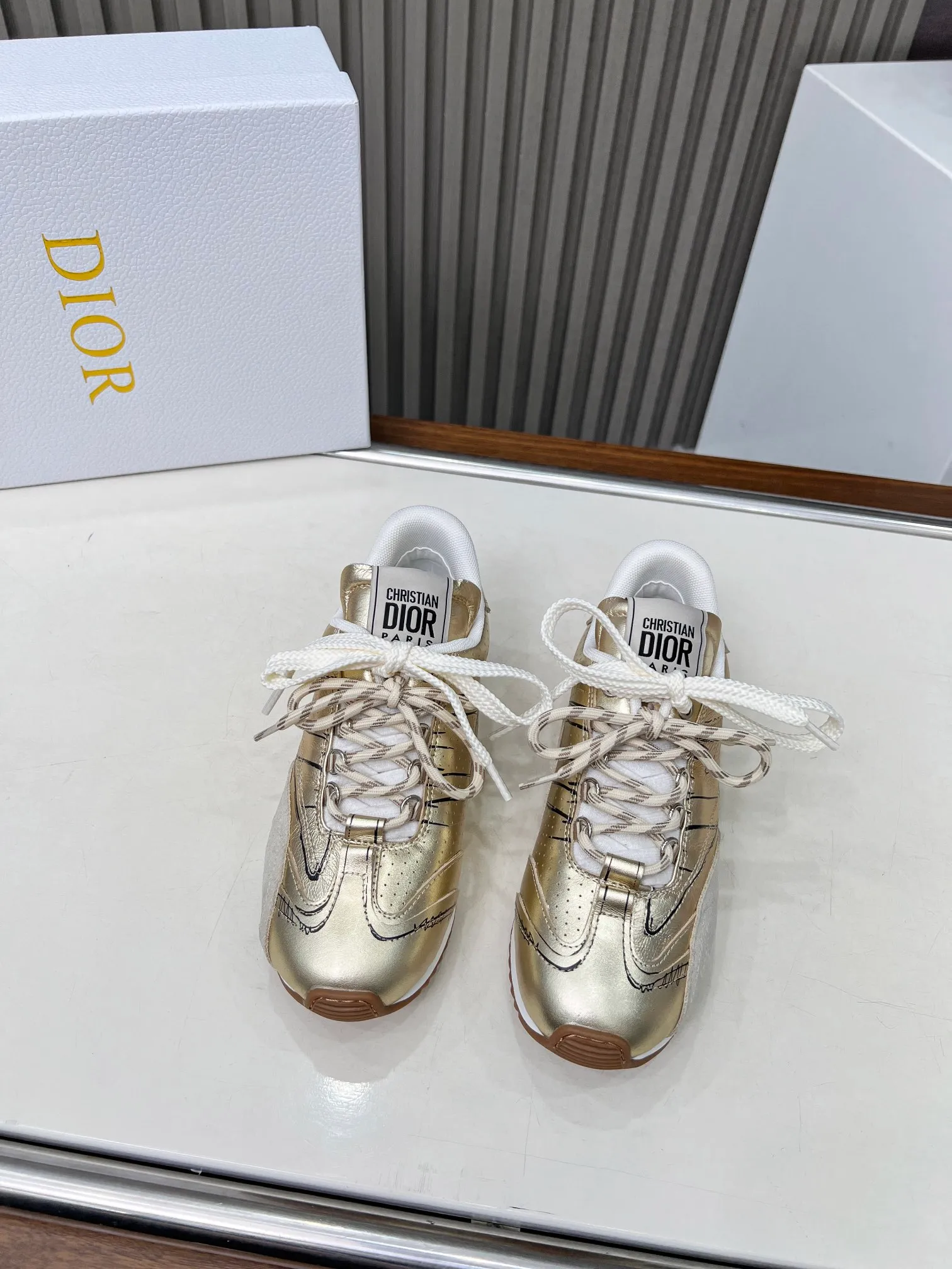 👟👟Ex-factory price 560👟👟 This D-Sketch sneaker is a new product of the 2025 spring and summer ready-to-wear series, highlighting the classic retro aesthetics. Crafted from gold-tone crinkled sheepskin and gold-toned laminated calfskin, it features a printed logo inspired by the shoe's production stages, as well as beige suede calfskin panels and double laces. Hand-written Christian Dior Paris signature on the side, Christian Dior Paris signature panels and plaques on the heel and tongue. Paired with two-tone slim rubber soles, they add a touch of couture to any casual look. Code number: 35~45 Color: black white gold silver